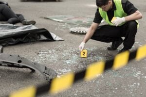 Why Evidence Preservation Can Make or Break a Personal Injury Case - Chiropractors.media Forensic investigator in a neon vest and gloves placing an evidence marker '2' at a crime scene, with caution tape in the foreground.